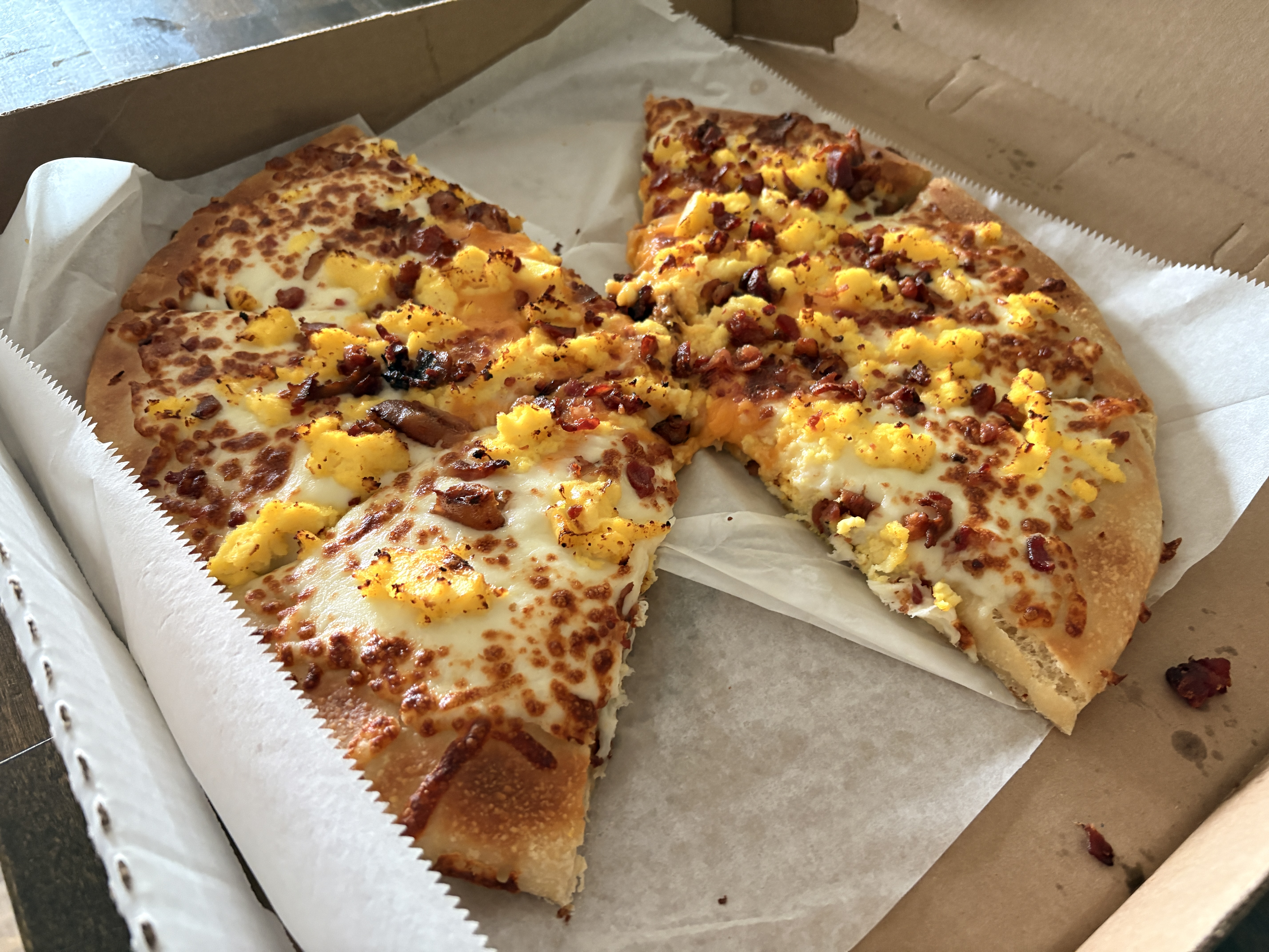 Breakfast pizza with eggs, bacon, and cheese