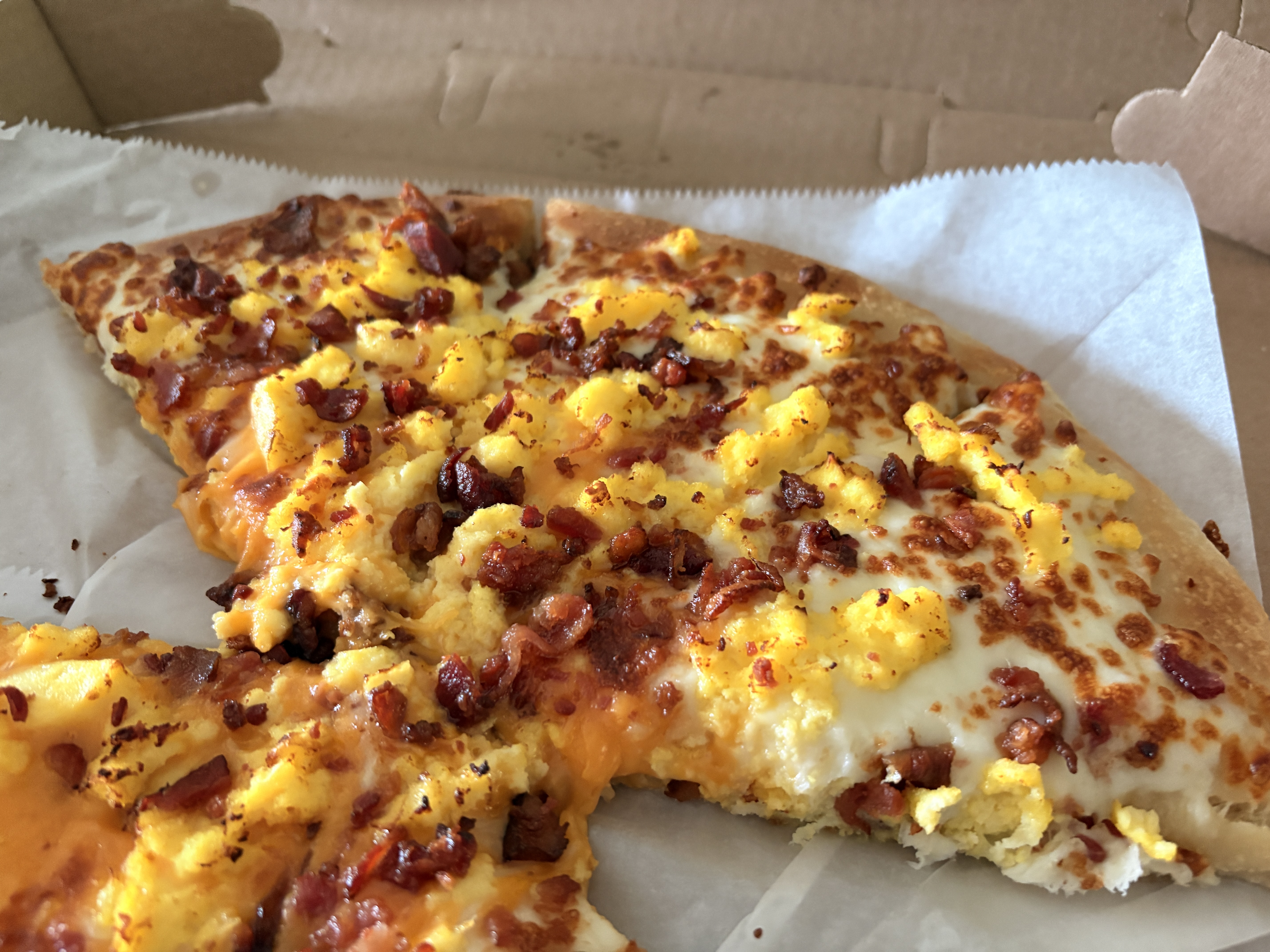 Breakfast pizza, close-up on the eggs and bacon