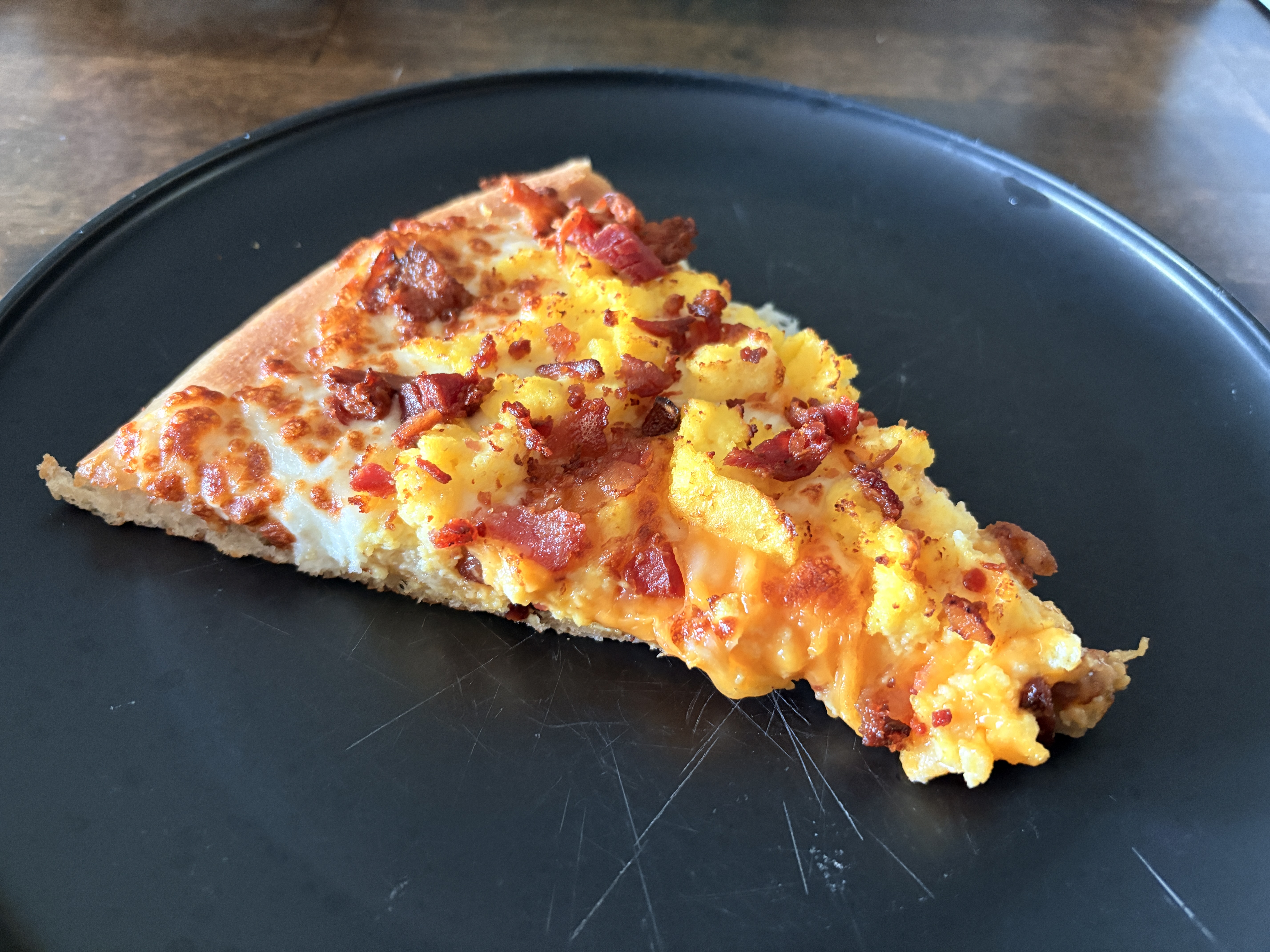 A slice of breakfast pizza on a plate